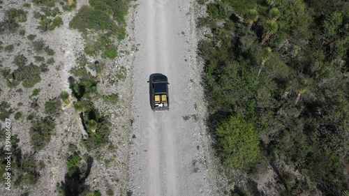 Top view by drone of a car amarok driving through mexican wasteland on dirt road photo