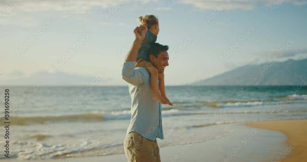 Father and son laughing and playing together on the beach at sunset Father and son laughing and playing together on the beach at sunset