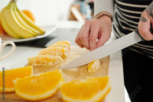 Close-up image of woman cutting oranges when cooking dinner at home
