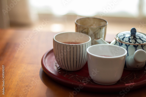 日の当たるテーブルに置かれた急須と入れたてのほうじ茶の入った湯飲み