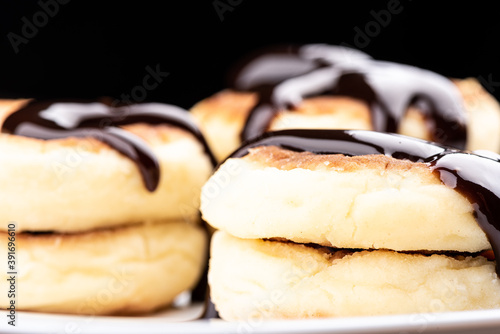 Selective focus. Close-up shot of cheese pancakes decorated with chocolate topping. Food background concept.