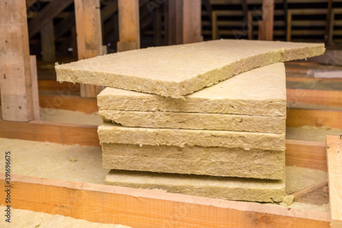 Insulation of the ceiling with fiberglass. Roof insulation. Laying and insulation with stone wool and fiberglass insulation material for a barrier against cold. The concept of building a warm house.