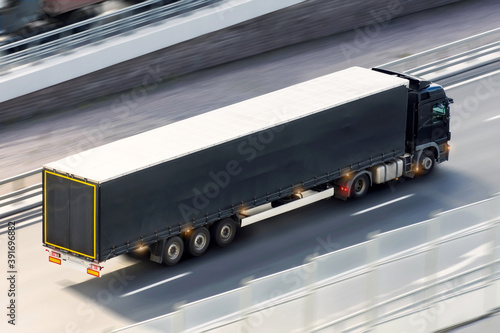 Black truck parking lights ride on blurry asphalt road rushes at high speed.