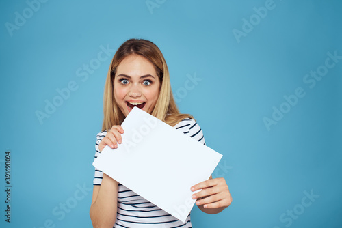 Woman holding sheet of paper striped T-shirt Copy Space cropped view blue background