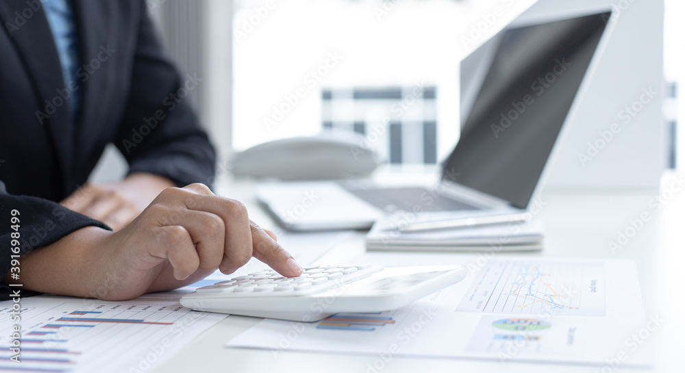 Young Asian woman analyzing financial work graph data in office. Young Asian woman analyzing financial work graph data in office.