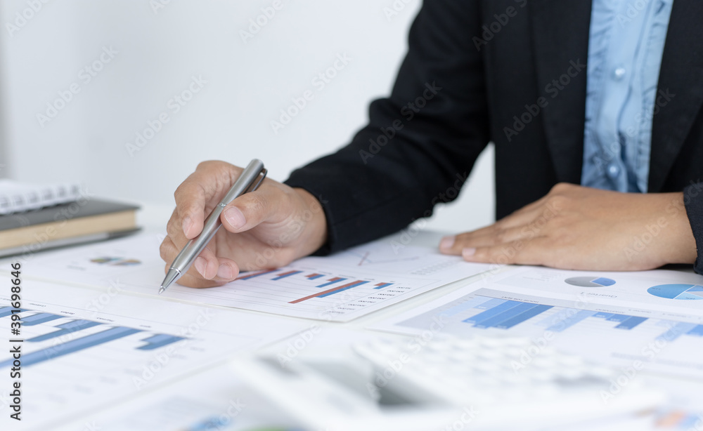 Young Asian woman analyzing financial work graph data in office. Young Asian woman analyzing financial work graph data in office.