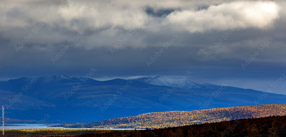 Stormy weather over the Khibiny mountains. The first snow on the top of the rocks.