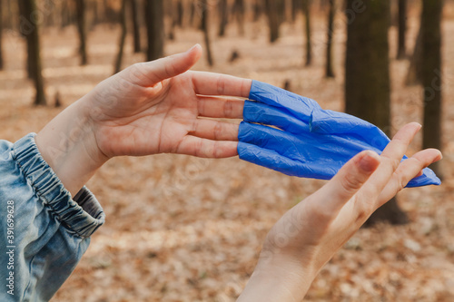 Hands take off rubber gloves in forest