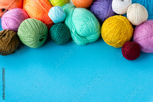 Various colored balls of yarn on a blue background. Threads for crocheting and knitting