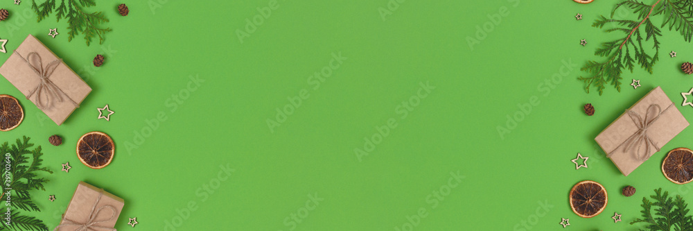 Fototapeta premium Banner with natural Christmas gifts, decorations and coniferous branches on a green background. Zero waste concept with copy space.