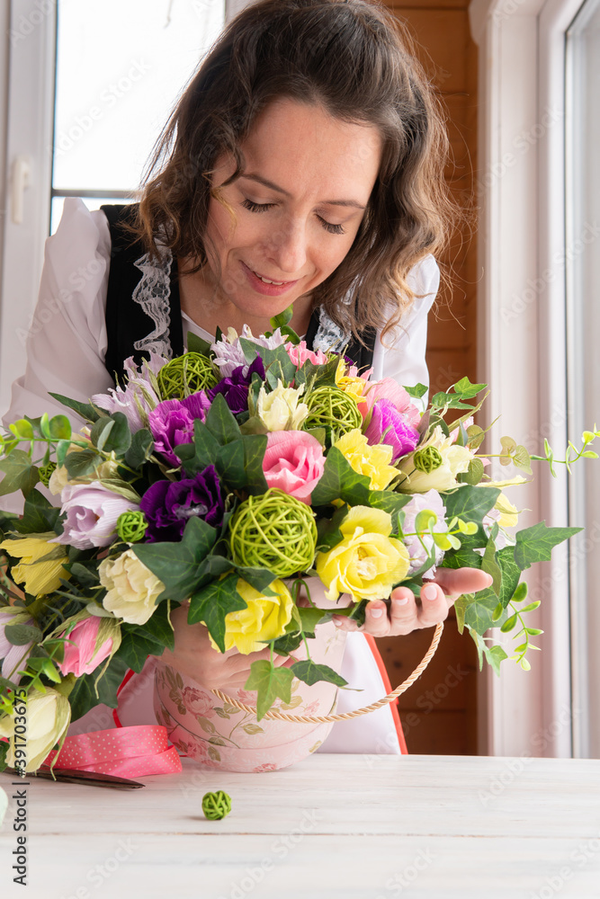 A woman collects a decorative bouquet of paper flowers. A woman collects a decorative bouquet of paper flowers.