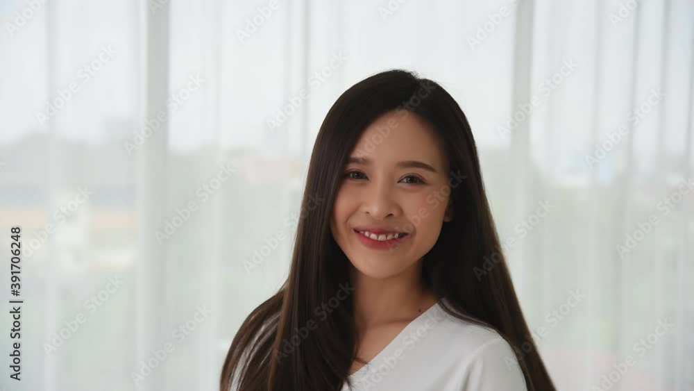 Young beautiful Asian woman in white casual outfit with smile and happy emotion turning around yourself Young beautiful Asian woman in white casual outfit with smile and happy emotion turning around yourself