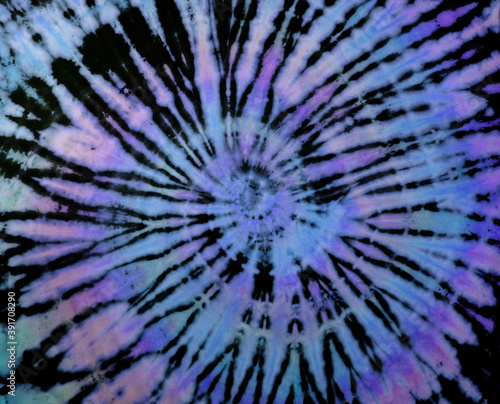 Spiral tie dye texture. Reverse swirl tiedye pattern. Tie-dye background in purple blue.