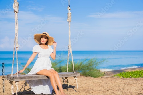 Portrait beautiful young asian woman relax smile on swing around beach sea ocean