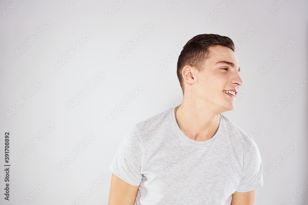 Man in a white t-shirt emotions gestures with hands close-up cropped view light background Man in a white t-shirt emotions gestures with hands close-up cropped view light background