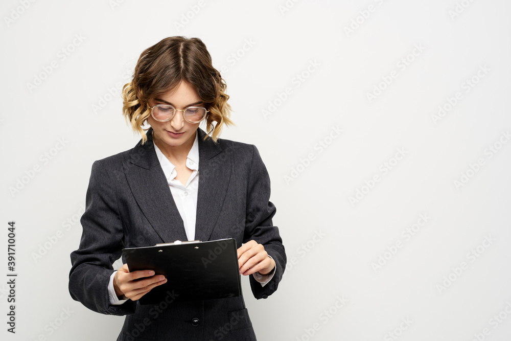 business woman in a suit with documents in hands light background curly hair hairstyle business woman in a suit with documents in hands light background curly hair hairstyle