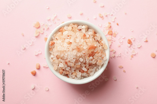 Bowl of pink himalayan salt on pink background