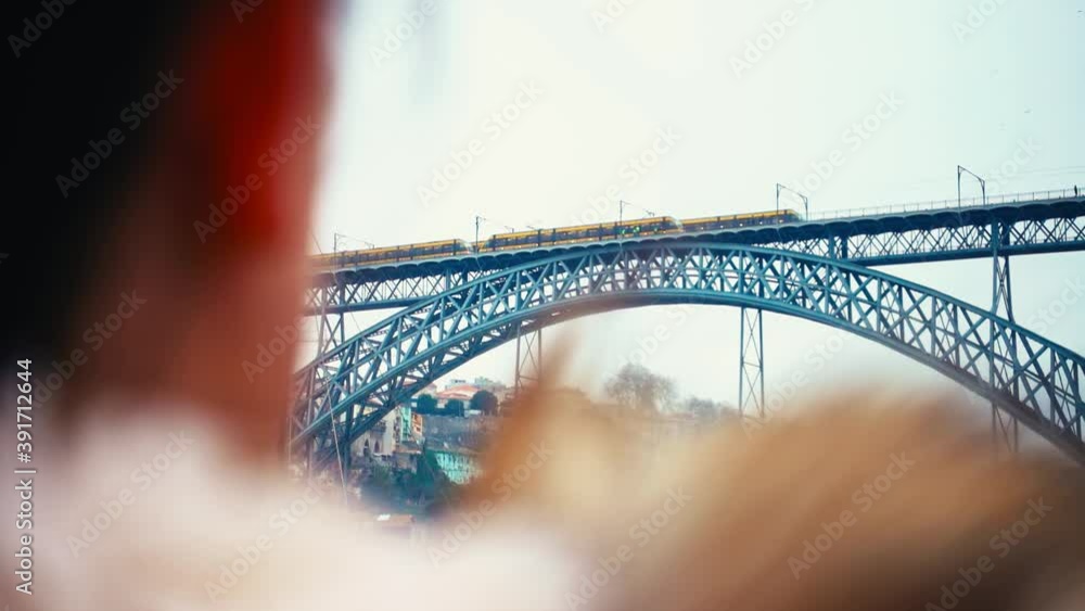 Over the shoulder shot of trains crossing the Dom Luis I Bridge in Portugal. Over the shoulder shot of trains crossing the Dom Luis I Bridge in Portugal.