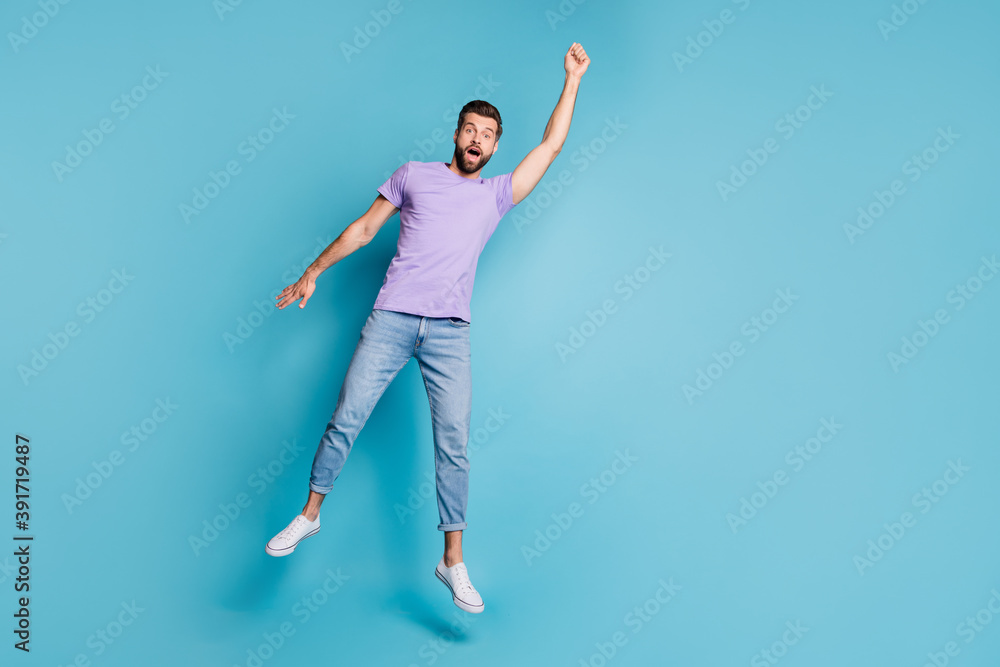 Full length body size photo of jumping man pretending superhero flying amazed in casual clothes isolated on bright blue color background