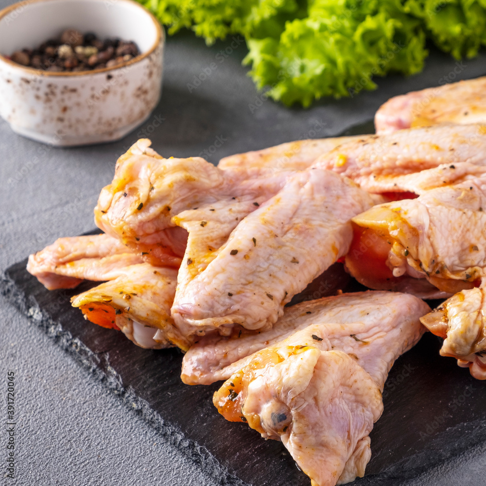 Raw chicken wings marinated in spices. Closeup Raw chicken wings marinated in spices. Closeup