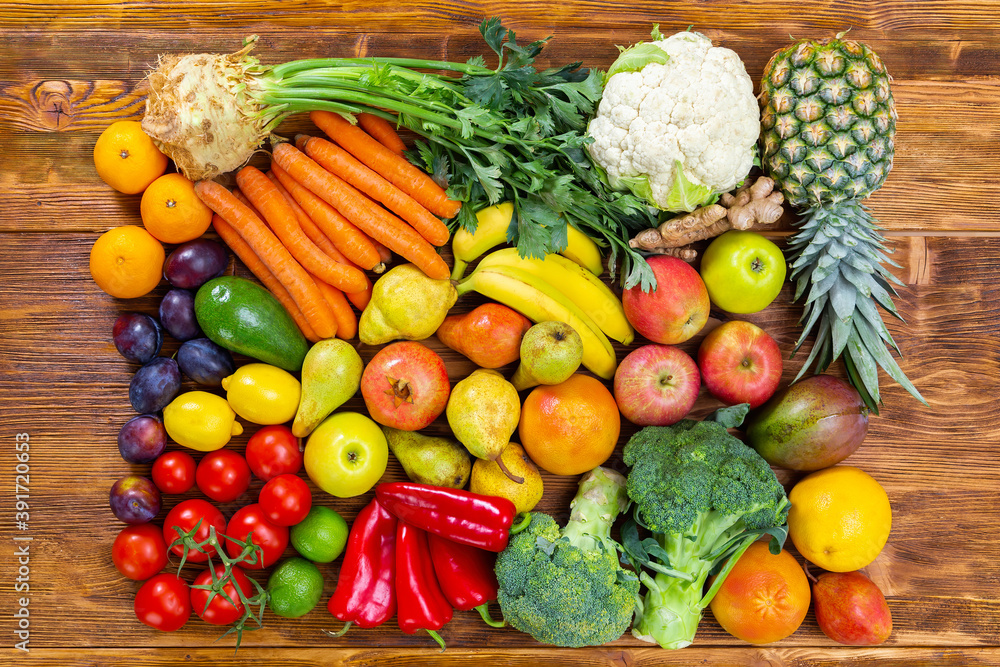Fresh raw fruit and vegetable on brown wooden table. Many sorts of healthy vegan food from garden on brown desk. Group of colorful plants lying flat from above. Fresh raw fruit and vegetable on brown wooden table. Many sorts of healthy vegan food from garden on brown desk. Group of colorful plants lying flat from above.
