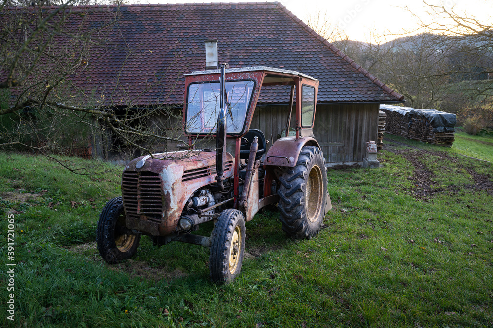 Rosttraktor hinter dem Bauernhaus