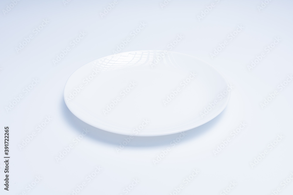 White plate with cutlery on white background White plate with cutlery on white background