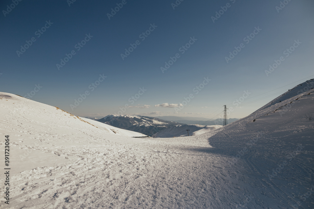 Panorama of Monte Terminillo, Rieti, Italy. Snowy mountains with blue sky. Copy space.