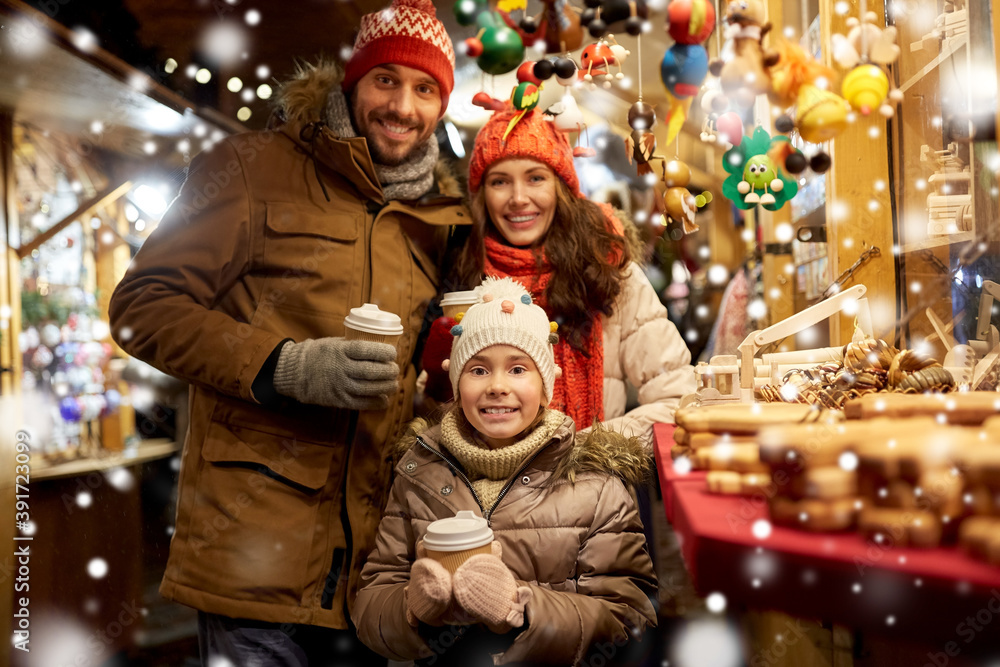 family, winter holidays and celebration concept - happy mother, father and little daughter with takeaway drinks at christmas market on town hall square in tallinn, estonia over snow family, winter holidays and celebration concept - happy mother, father and little daughter with takeaway drinks at christmas market on town hall square in tallinn, estonia over snow