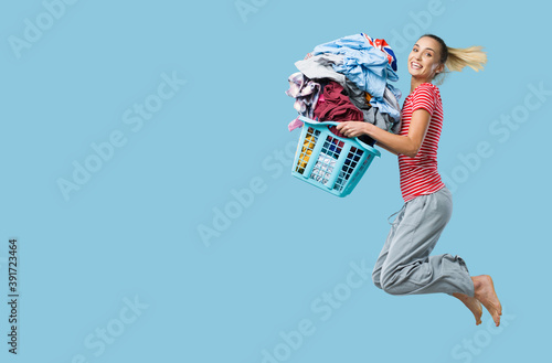 Happy woman doing laundry and jumping photo