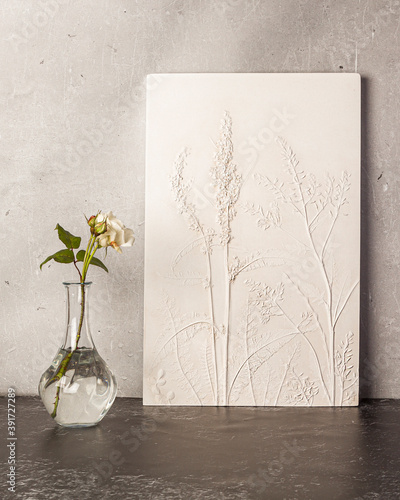 Stylish living room interior with botanical bas-relief wildflowers for wall artand flowers in vase. 3D Flower plaster decor. Modern and luxury interior of room. photo