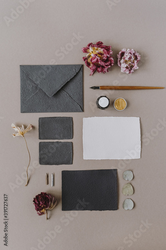 Flat lay empty blank paper card, envelope, pen, flower buds on beige background. Wedding invitations cards. Flatlay, top view copy space collage. Template for blog, website, social media. photo