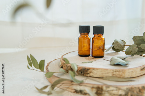 木とアロマオイルビンが2本。自然・オーガニック・美容のイメージ。