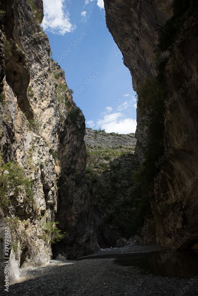 Point of view inside the breathtaking Venetikos river in Portitsa Gorge. Part of the sky appears between the high cliffs of 150-200 meters. Grevena, Greece.