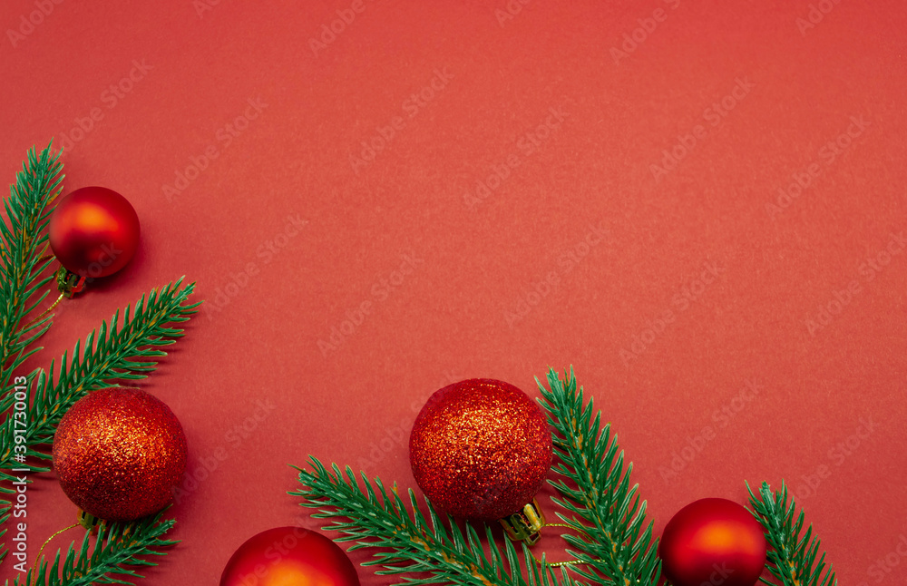 Red Christmas balls with fir branches on a red background