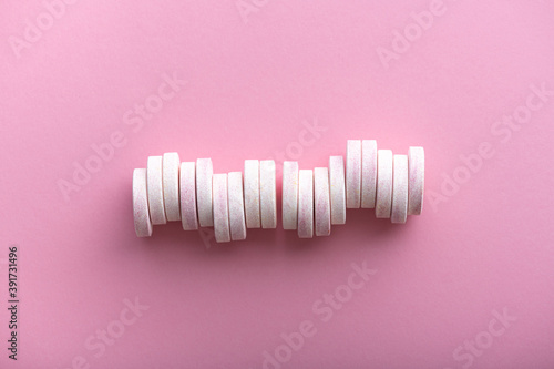 effervescent tablets on pastel pink background, top view