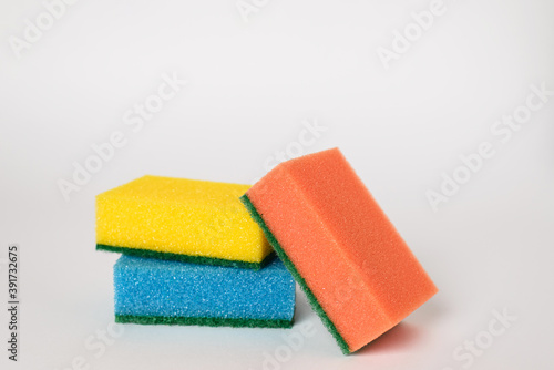 Close-up photo of multi-colored foam cleaning sponges on a white background