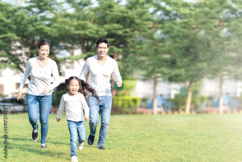 Young attractive happy asian family playing by running together in outside nature park in home school learning or montessori concept with white and blue casual wearing. Asian lifestyle parenting. © ChayTee