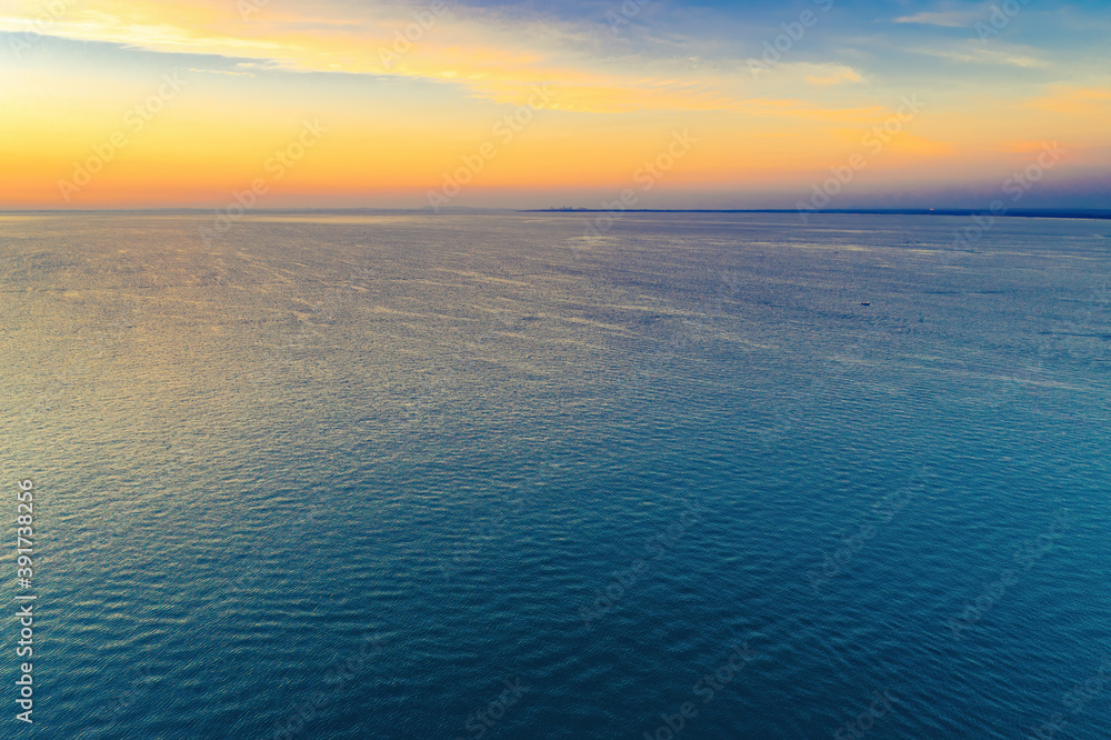 Aerial view of dawn over ocean with distant coastline