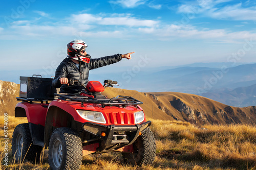 A man on a quad bike in the mountains. 