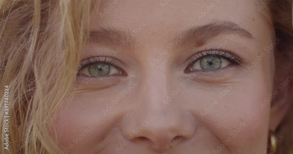 Portrait of attractive female model face looking to camera. Close up of young woman with short blond hair and light green eyes smiling. Concept of lifestyle. Blurred green background Portrait of attractive female model face looking to camera. Close up of young woman with short blond hair and light green eyes smiling. Concept of lifestyle. Blurred green background