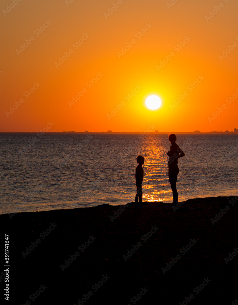 people on the seashore during sunset