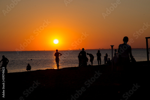 people on the seashore during sunset