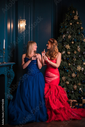 Two women in red and blue luxurious dress, Christmas eve, inspiration clothes for party, evening dress collection 
