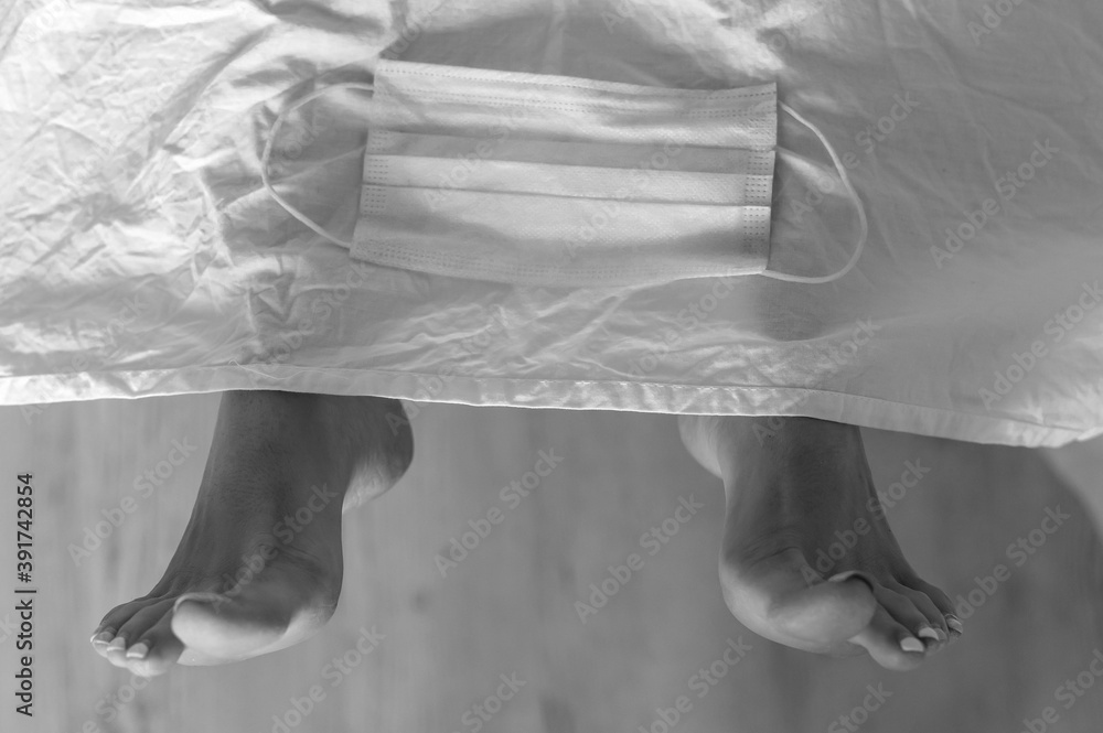Feet of a dead woman in a morgue with a mask. Victim of the coronavirus epidemic. Feet of a dead woman in a morgue with a mask. Victim of the coronavirus epidemic.