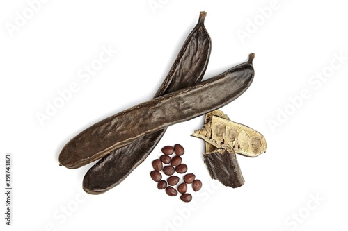 Carob beans with seeds isolated on white background.
