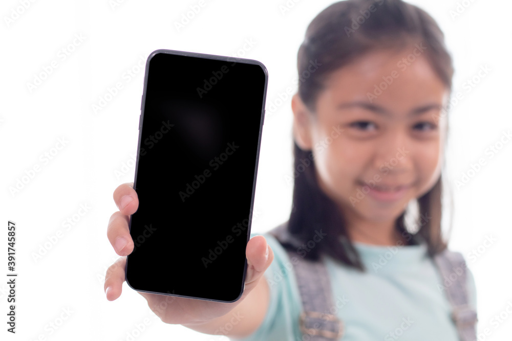 Adorable Asian smart girl in casual playing game or texting to friend on smartphone, happy schoolgirl sit on sofa using phone technology searching information study learn from home social distance