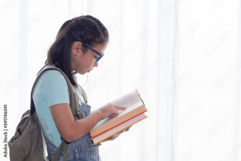 Adorable Asian smart girl in casual jean hold stack of books, adorable intelligent school girl primary looking her many book with happy, girl study at home social distance back to school concept Adorable Asian smart girl in casual jean hold stack of books, adorable intelligent school girl primary looking her many book with happy, girl study at home social distance back to school concept