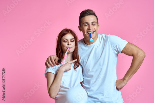 pregnant mom and happy father on pink background Young family waiting for baby