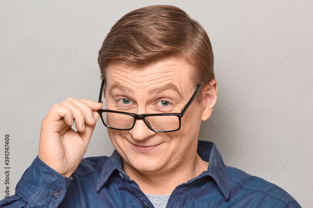 Portrait of happy blond mature man looking over his glasses at you Portrait of happy blond mature man looking over his glasses at you